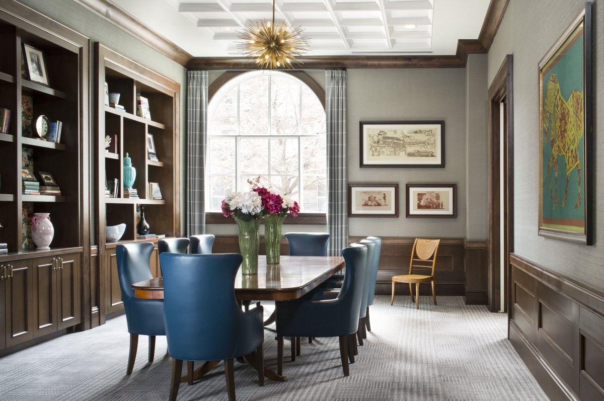 A beautifully designed dining room featuring blue chairs, a large window, and elegant decor.