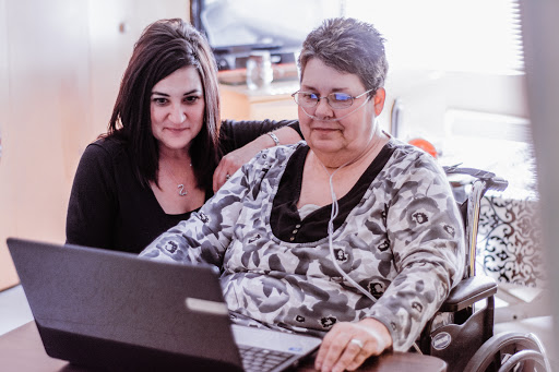 Two women engaging with a laptop, showcasing a moment of connection and learning.