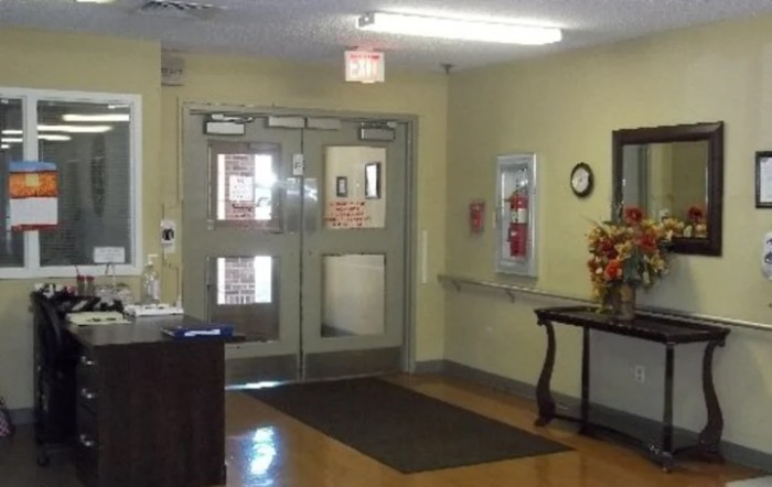 A view of an indoor entrance hallway with double doors and a fire extinguisher on the wall.
