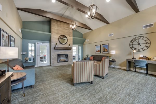 A cozy living room with a vaulted ceiling, featuring a stone fireplace and comfortable seating.