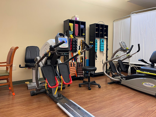 A well-equipped rehabilitation gym featuring various exercise machines and tools for fitness and therapy.