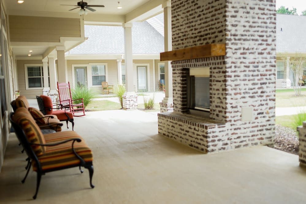 A spacious patio with a brick fireplace and comfortable seating.