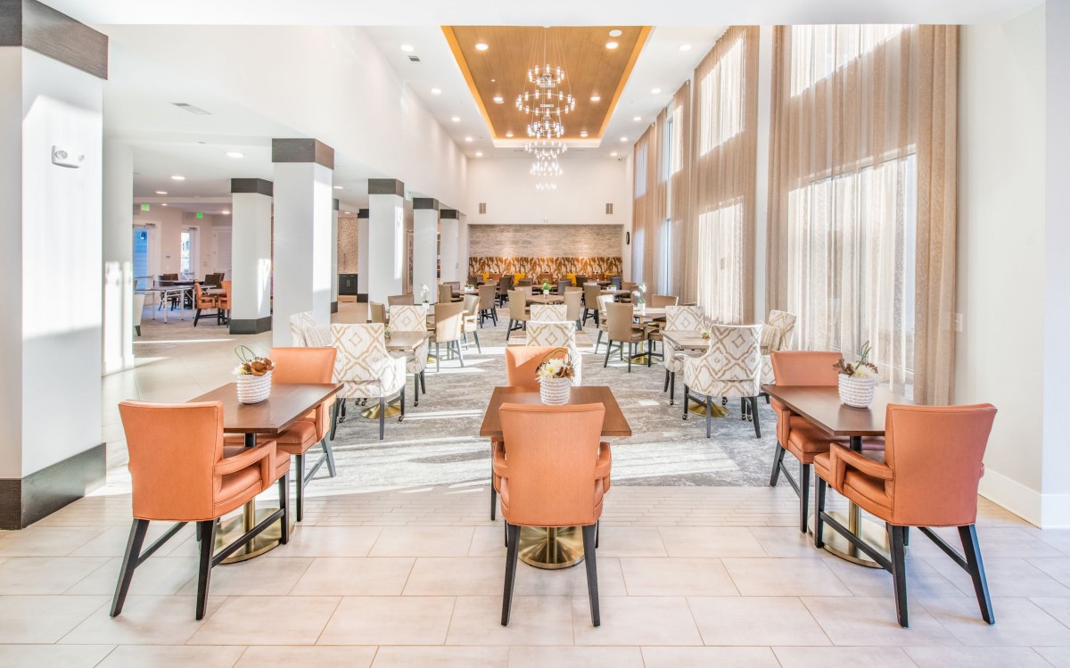 A modern dining area with stylish furniture and elegant chandeliers.