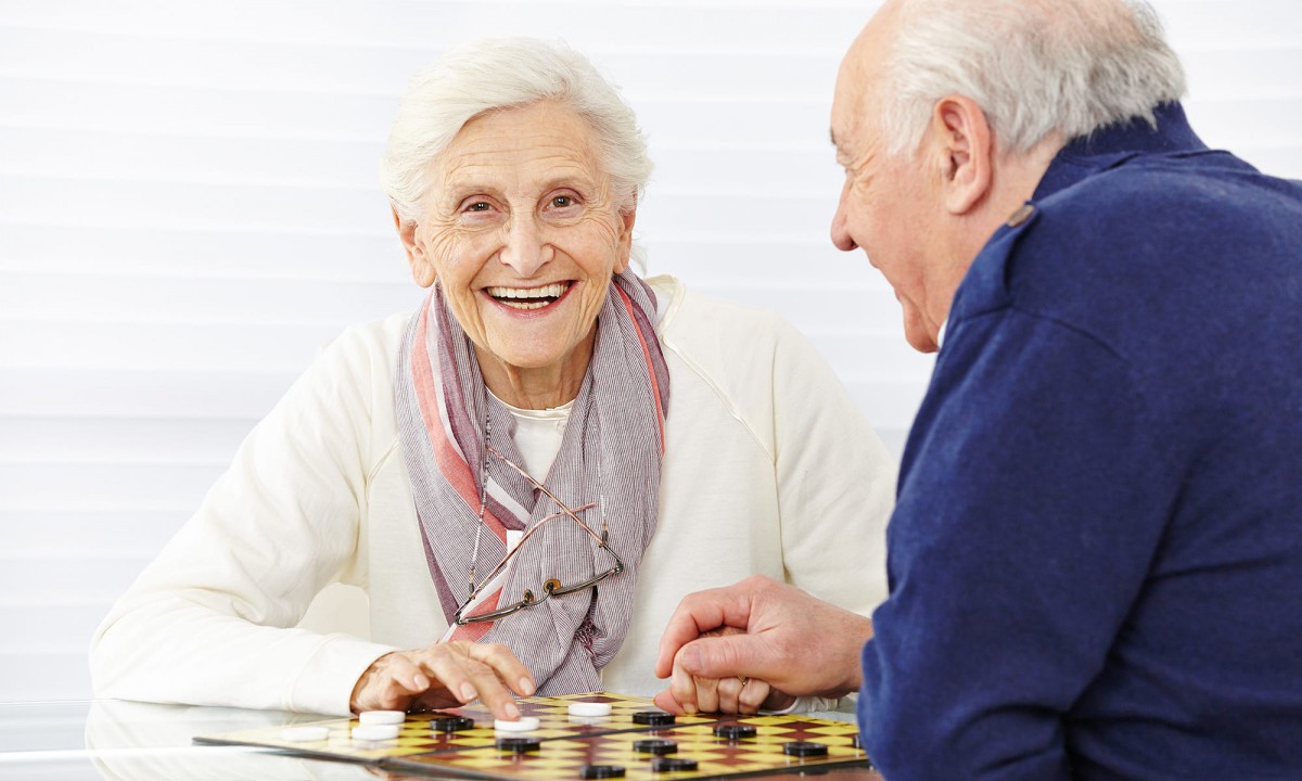 Two senior individuals enjoying a game of chess together.