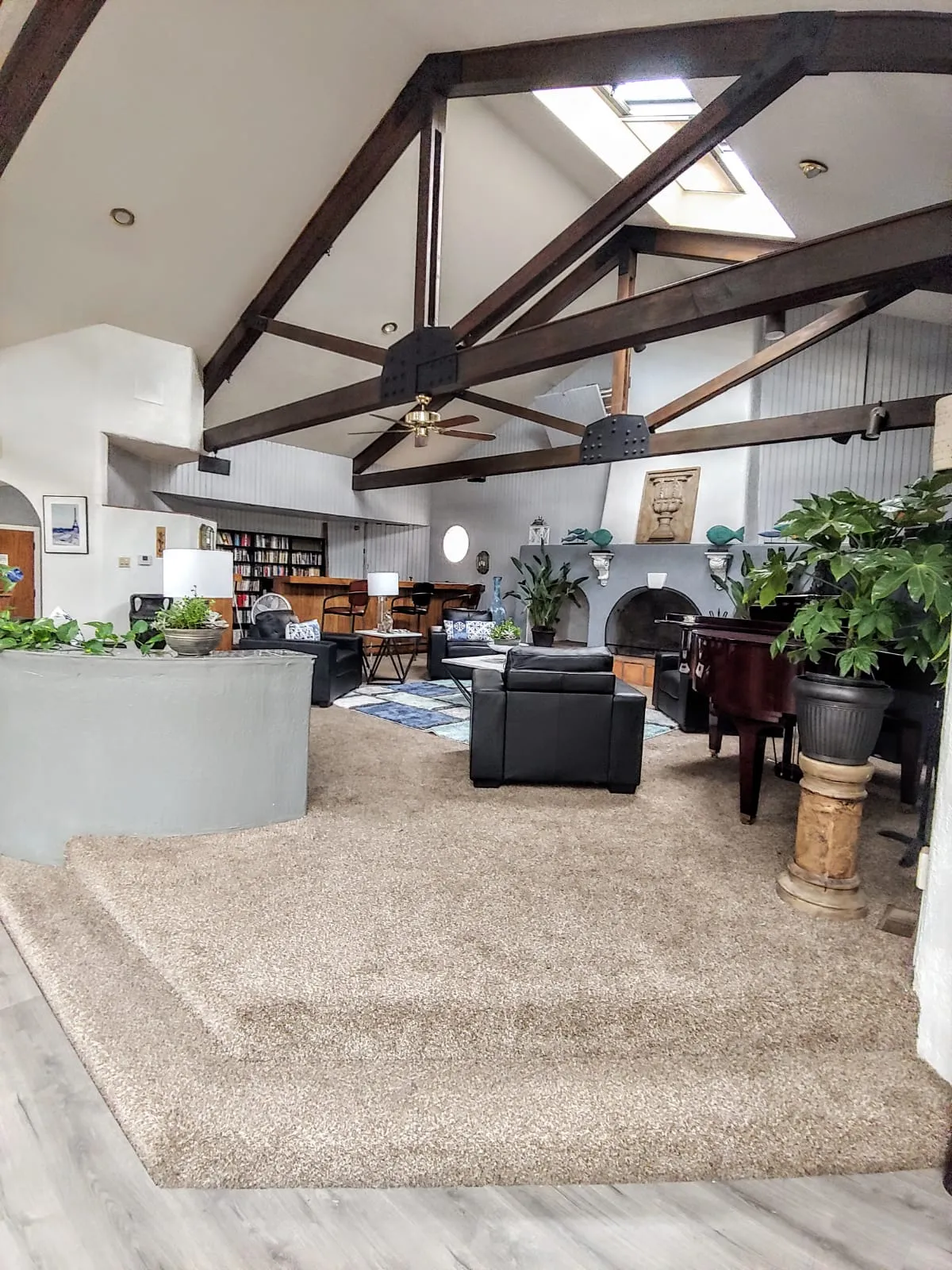 Spacious living area with exposed beams and abundant natural light.