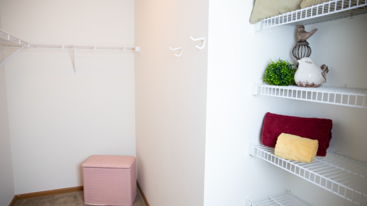 Organized closet space with neatly arranged shelves and a storage box.