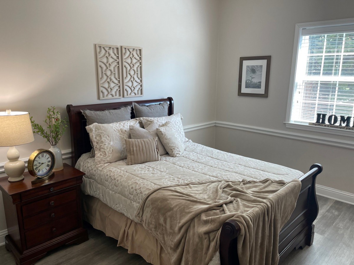 A cozy, well-decorated bedroom with a neatly made bed, pillows, and soft blankets.