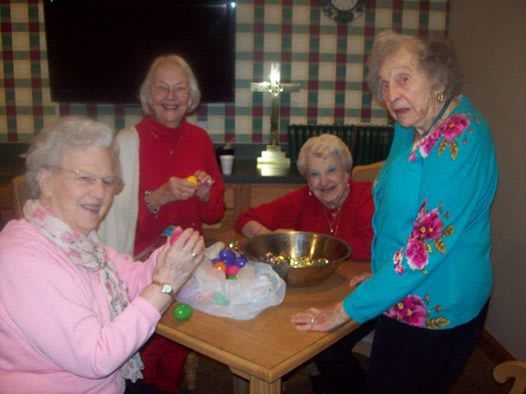A group of elderly women enjoying a leisure activity together indoors.