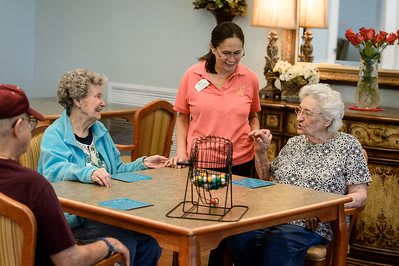 A group of elderly individuals engaging in a bingo game at a community care home.