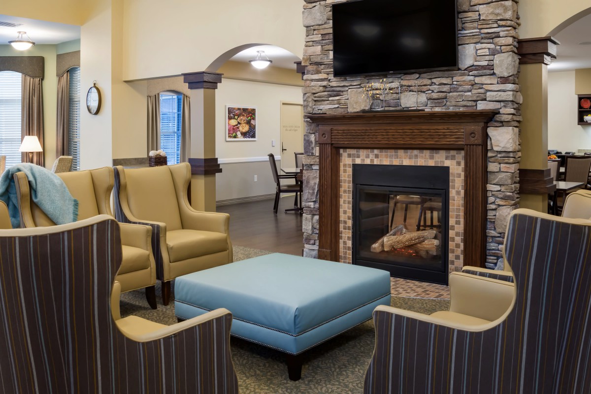 A cozy living room with armchairs and a fireplace.