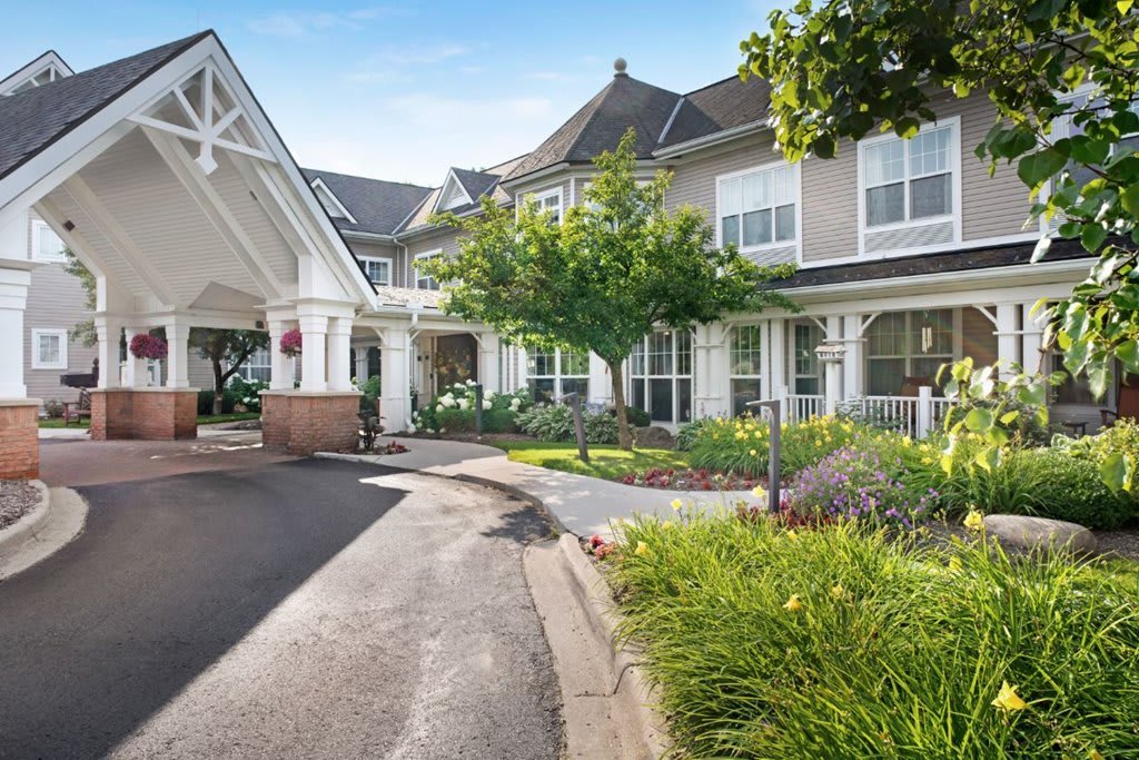 A well-landscaped building entrance with a driveway leading up to it.