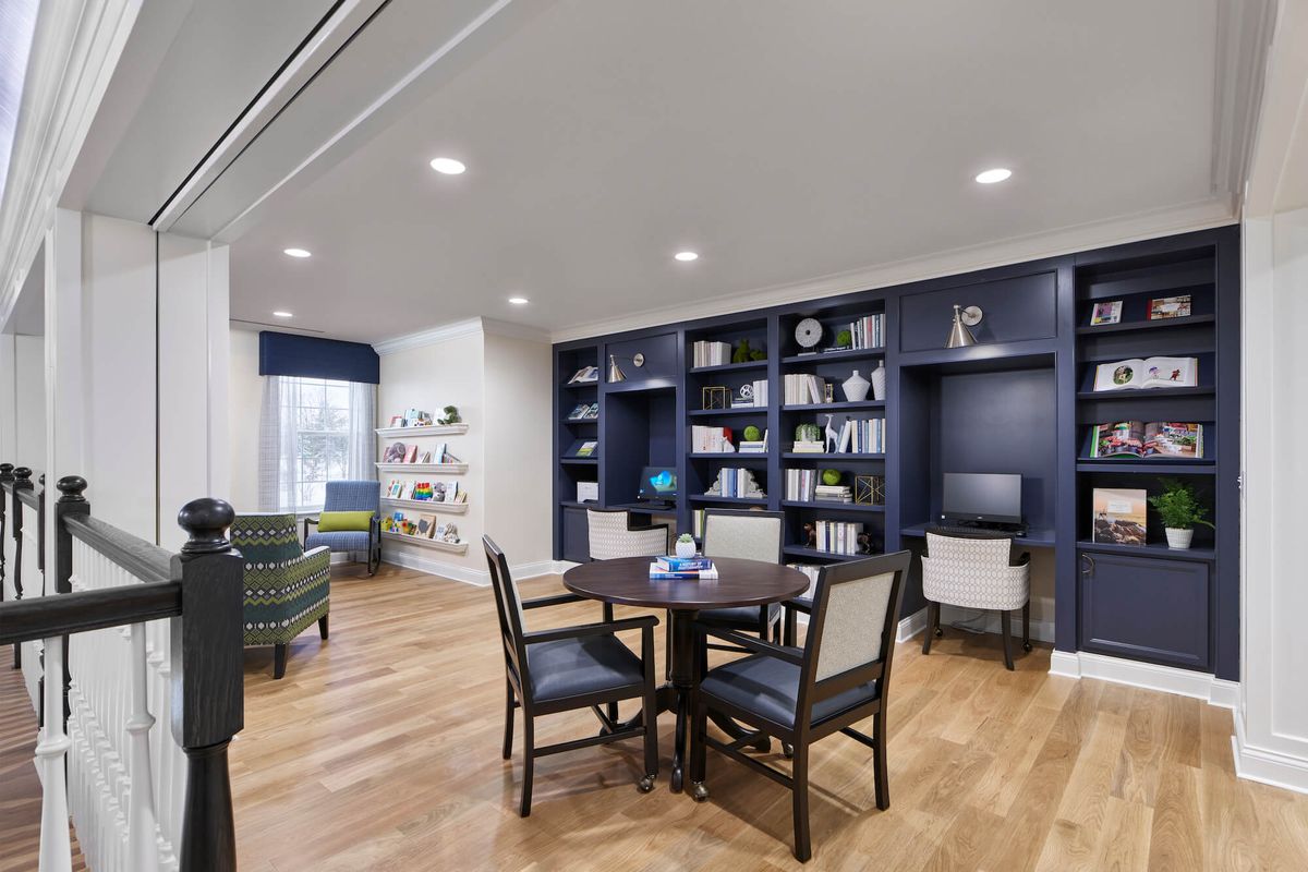 A modern library with a seating area and bookshelves.