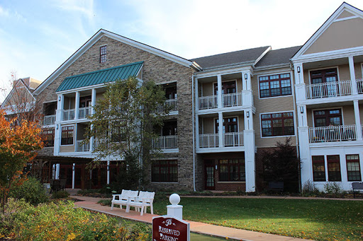 A residential building featuring stone architecture and balconies, set in a landscaped area.