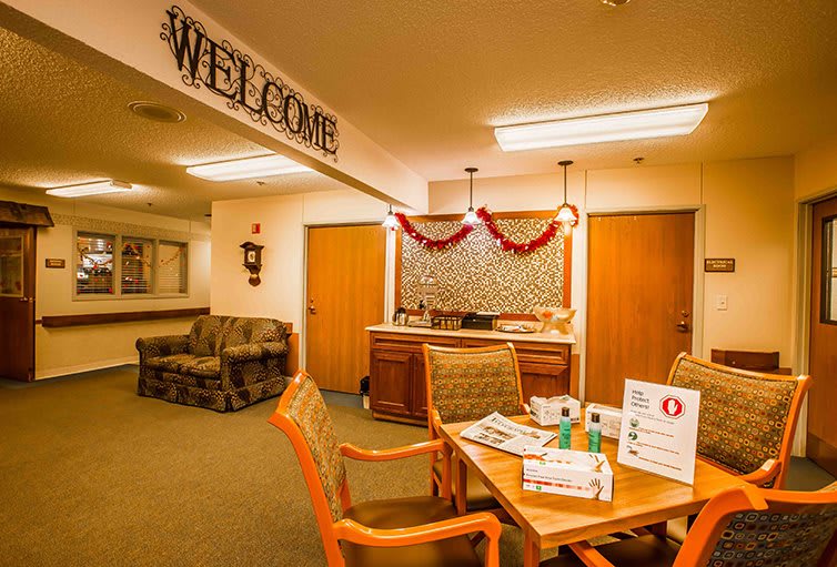 A warmly decorated lobby area with a welcome sign, featuring seating arrangements and a table with informational materials.
