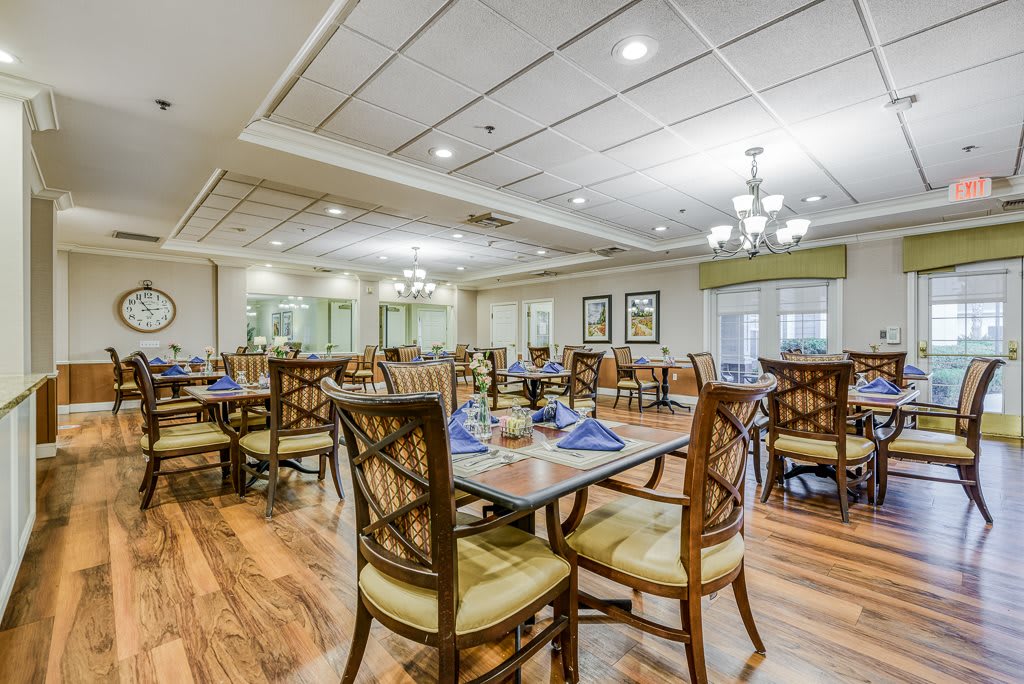 An elegant dining area with neatly arranged tables and chairs, well-lit and ready for guests.