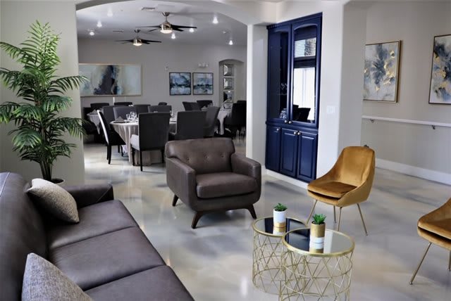 A modern living room with sleek furniture and a dining area in the background.