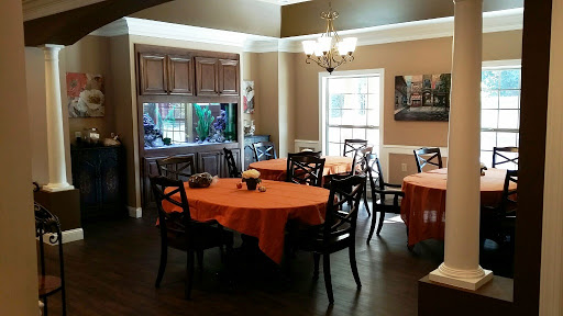 A cozy dining room set up with orange tablecloths, creating a warm and inviting atmosphere.