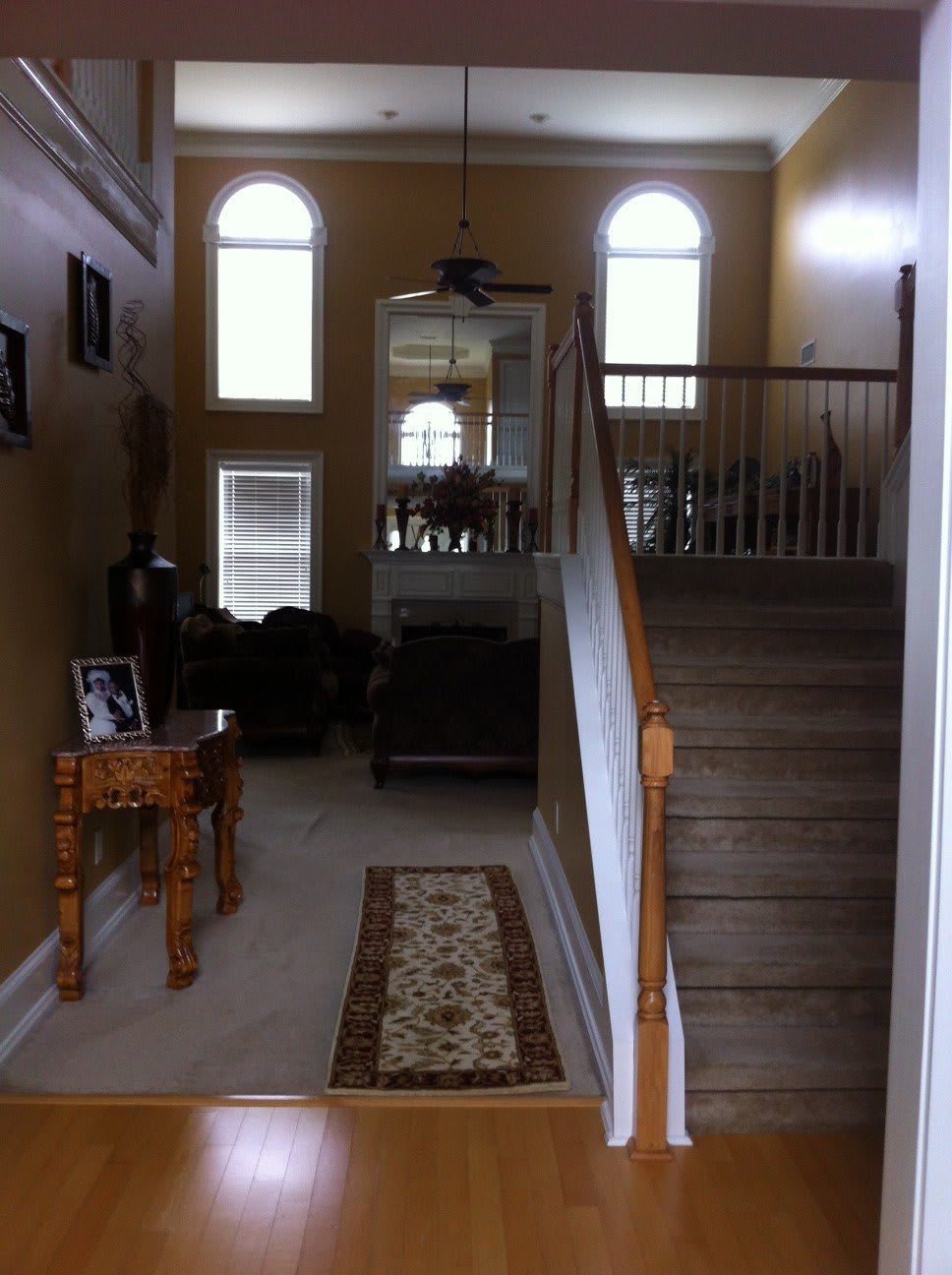 A well-lit interior view of a house with a staircase and living room area.