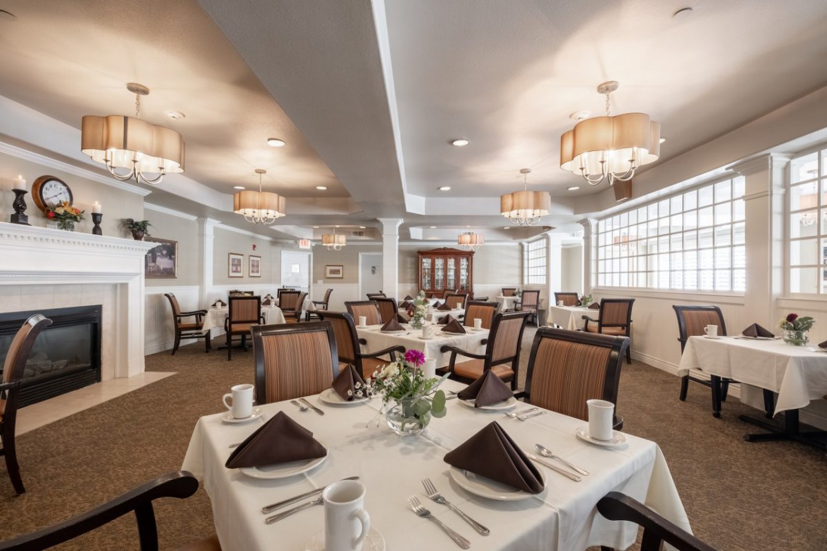 A formal dining room with neatly arranged tables and elegant lighting.