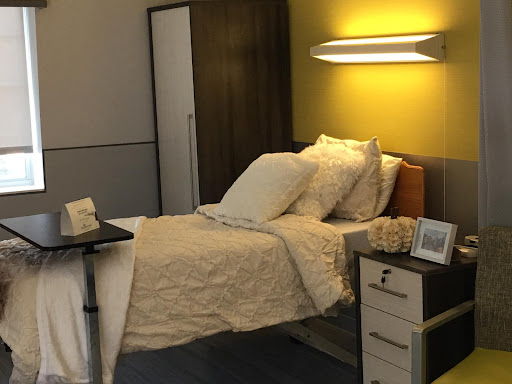 A cozy, well-lit bedroom featuring a neatly made bed and modern furniture.