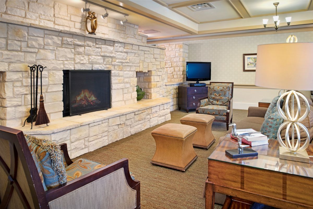A cozy living room with a stone fireplace and comfortable seating.