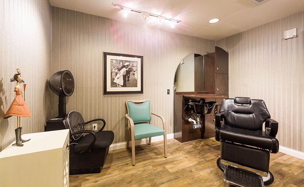 A cozy hair salon interior with styling chairs and a mirror.