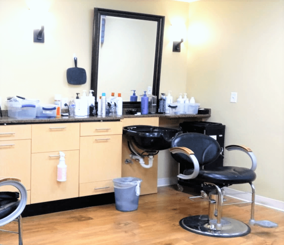 A neatly organized hair salon with styling chairs, mirrors, and various beauty products on display.