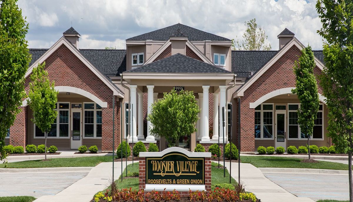A stately brick funeral home with columns and manicured landscaping.