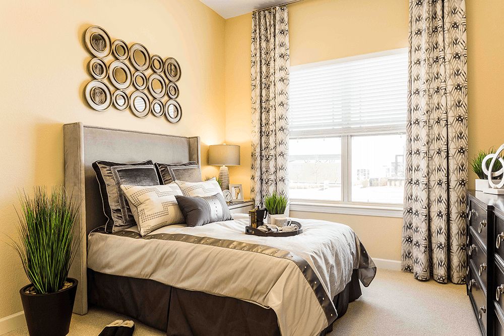 A modern bedroom with stylish decor, featuring a neatly made bed and decorative wall art.