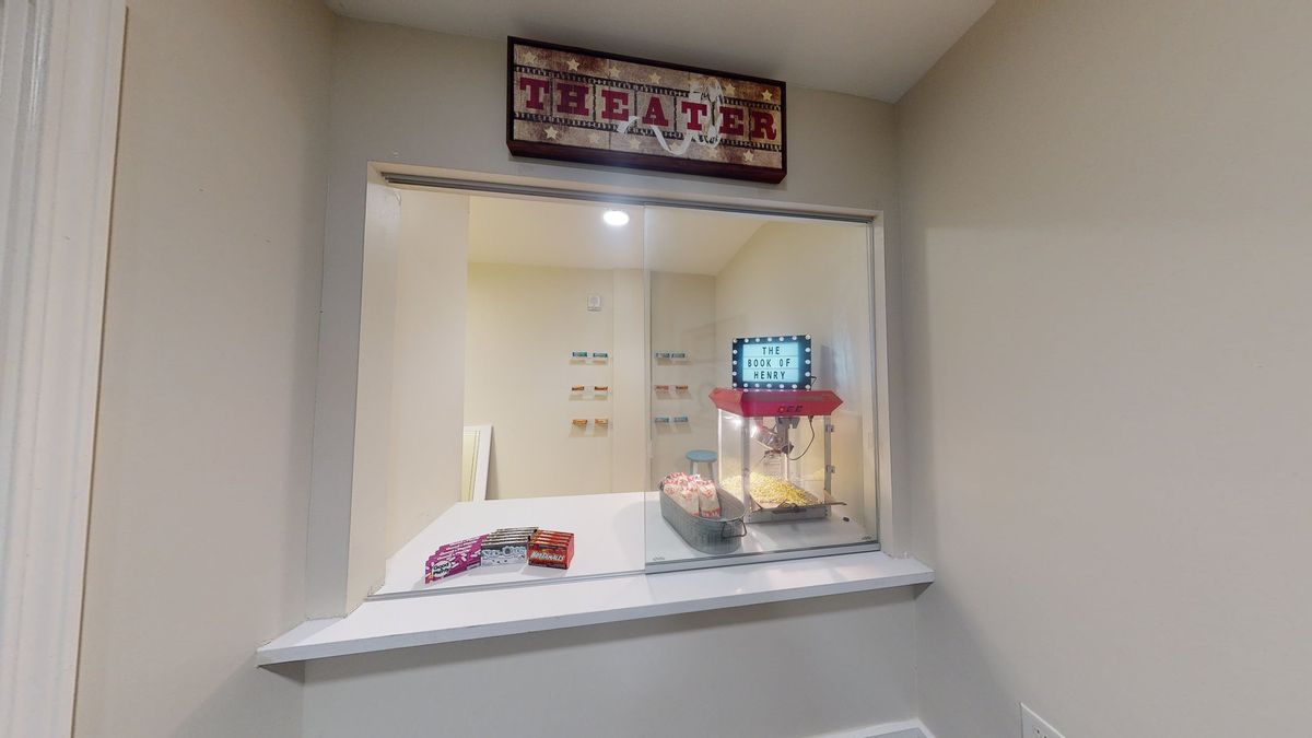 A theater concession stand with a popcorn machine and candy displayed.