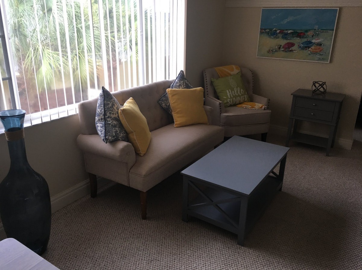 A cozy living room with a sofa, colorful cushions, and a coffee table.