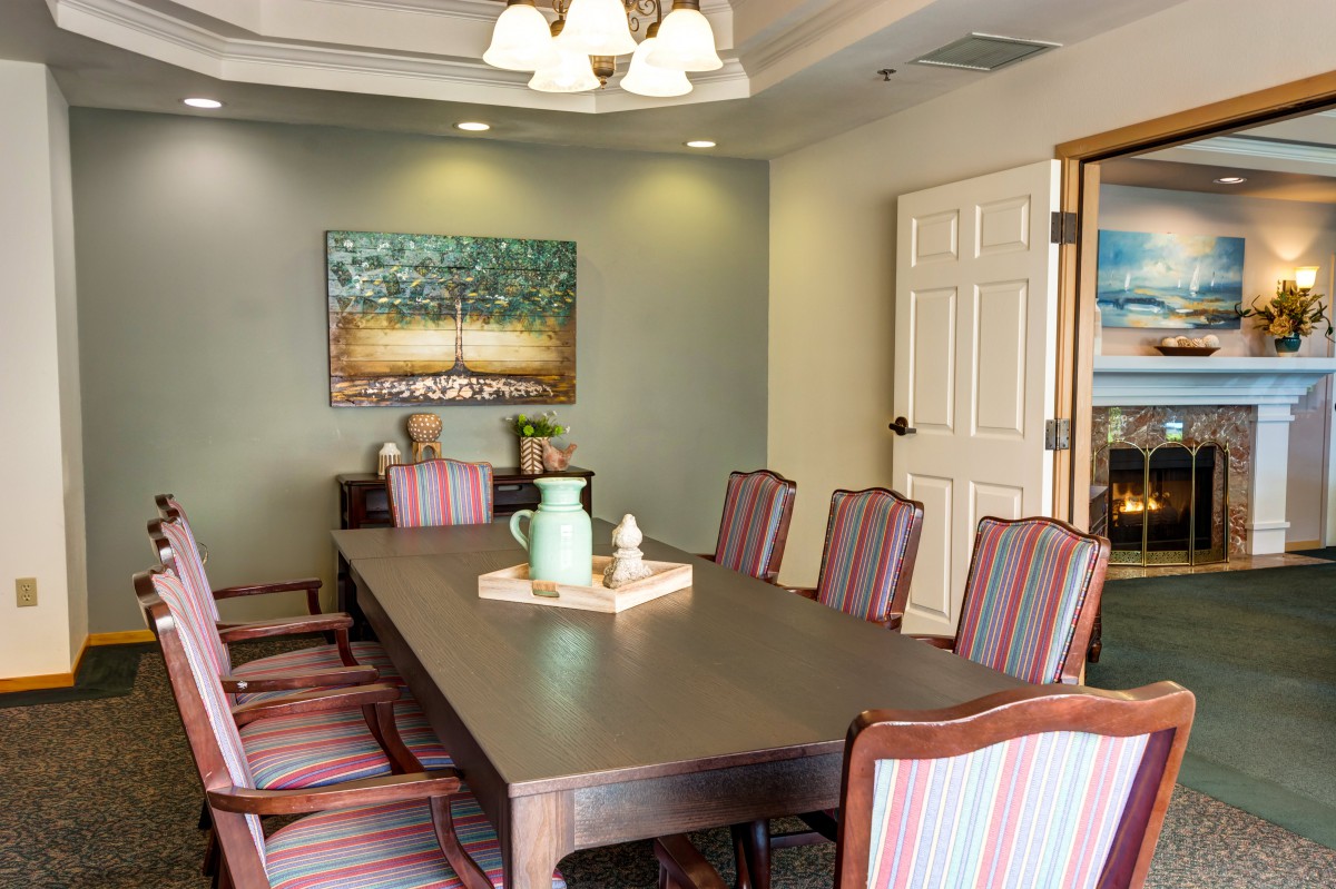 A conference room with a long table, several chairs, and decorative elements.