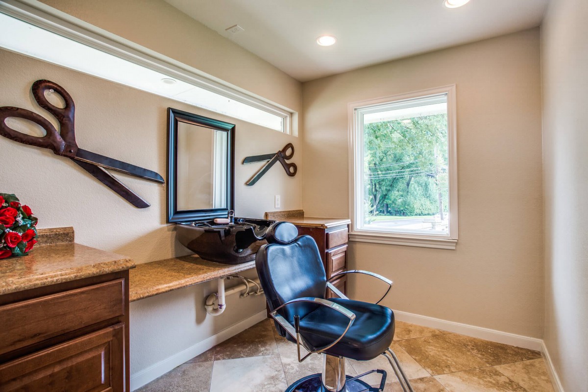 A modern hair salon with a barber chair, mirror, and stylish decor.