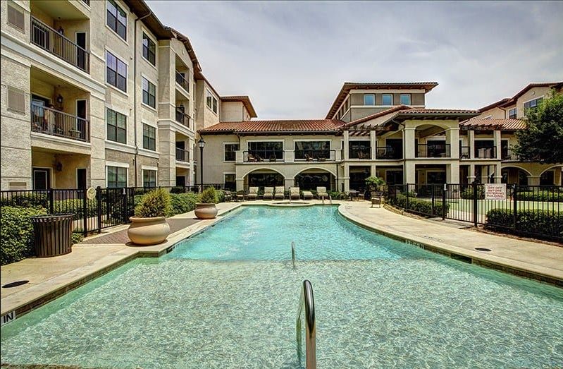 A luxury apartment complex with a large outdoor swimming pool.