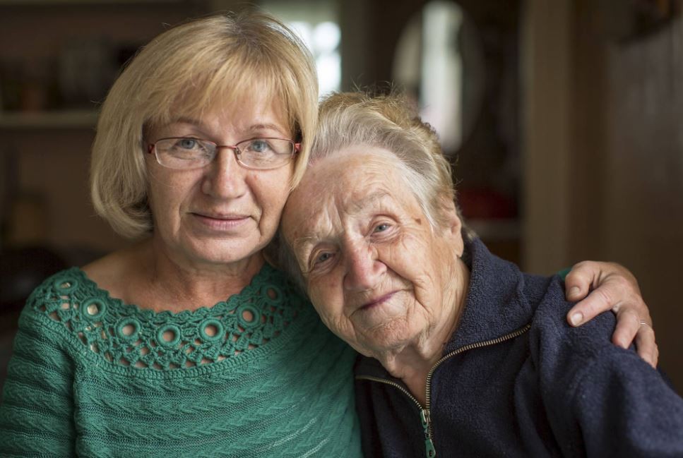 Two women, possibly family members, sitting together indoors.