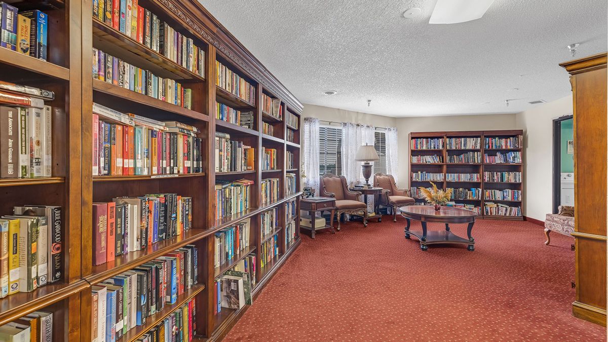 A cozy library with bookshelves filled with books, featuring comfortable seating and a warm atmosphere.