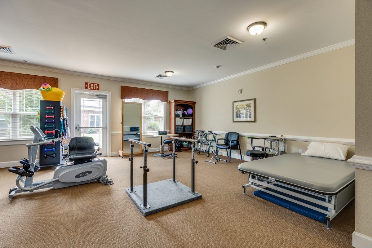A well-equipped physical therapy room with exercise machines and rehabilitation equipment.