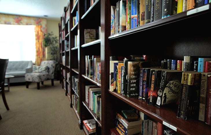 A cozy library room with rows of bookshelves filled with a variety of books.