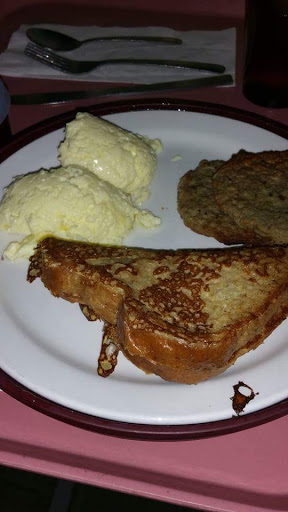 A delicious breakfast plate featuring French toast, scrambled eggs, and a pancake.