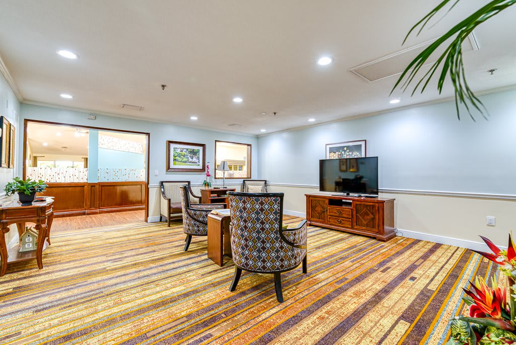 A modern lounge area with comfortable seating and a large television.
