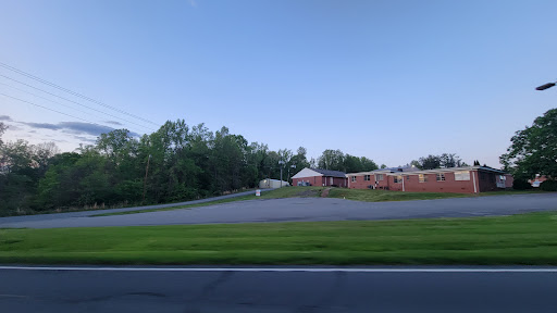 A peaceful scene of a building surrounded by trees and open space, captured during twilight.