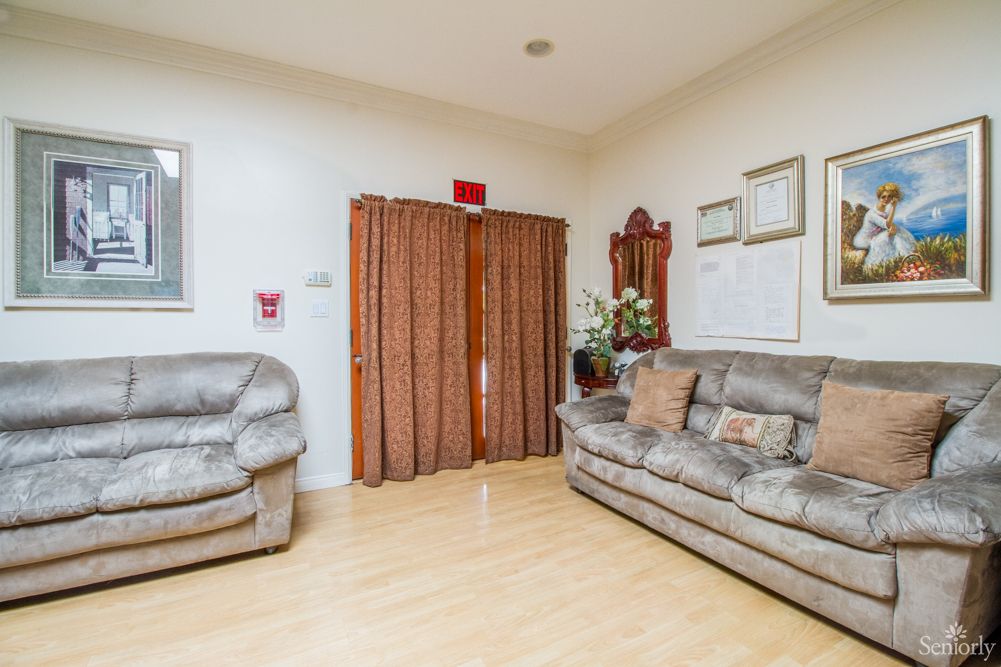 A cozy living room with a sofa and armchair, featuring hardwood floors and decorative elements.