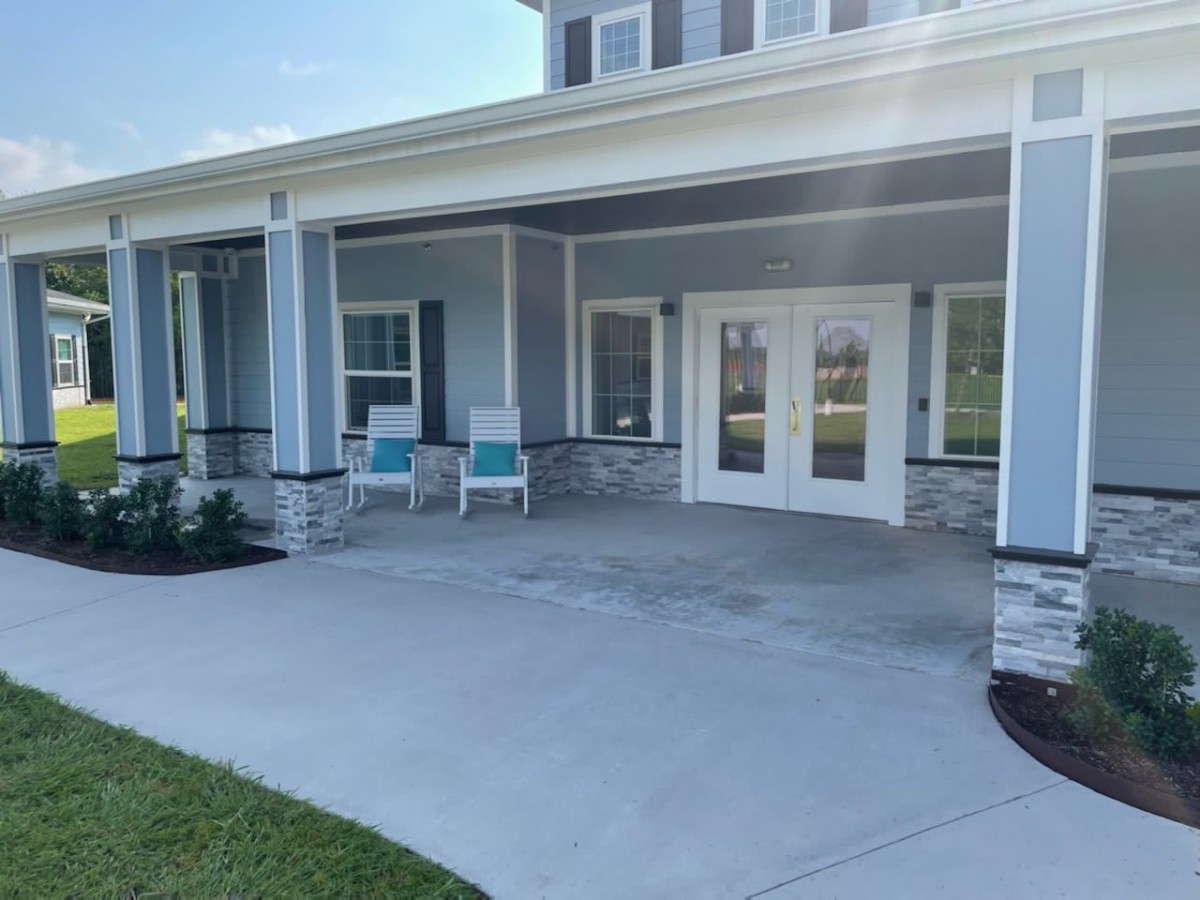 A spacious porch with chairs and a view of the house exterior.