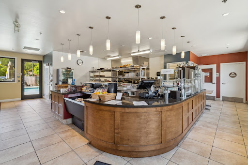 Inside view of a modern caf featuring a wooden counter and an organized kitchen area.