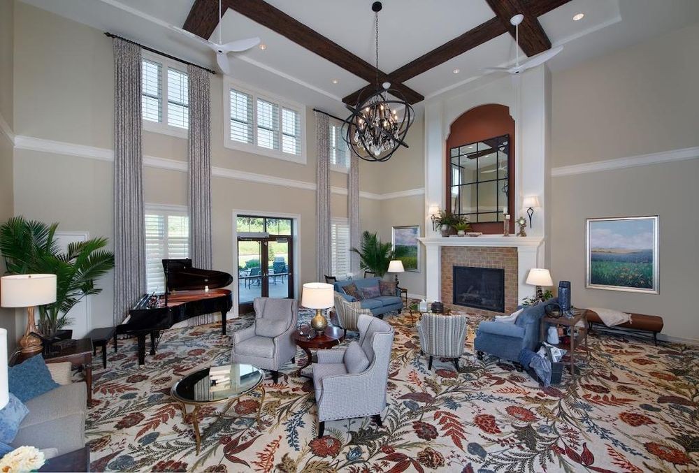 Spacious living room with elegant decor, featuring a grand piano and fireplace.