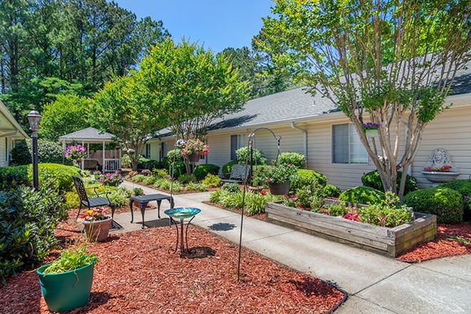 A beautifully landscaped garden with benches and a pathway surrounded by greenery.