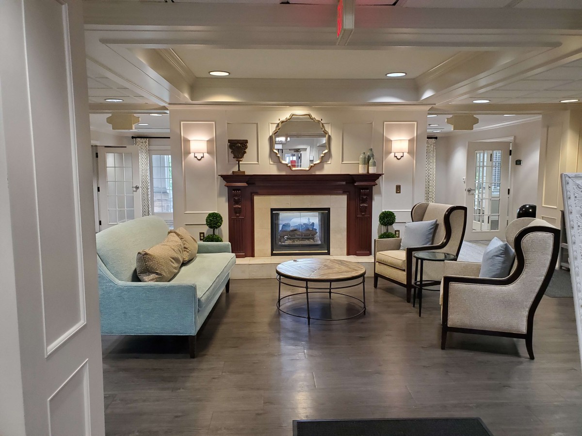 A beautifully designed living room featuring a fireplace, elegant furniture, and a decorative mirror.
