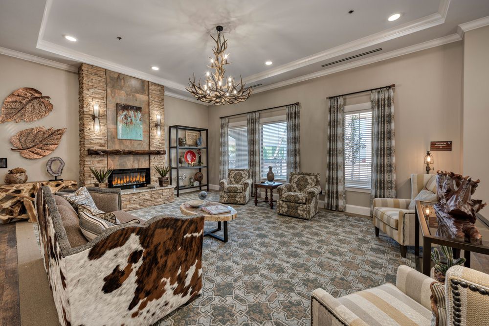 A cozy living room with elegant furniture, a fireplace, and a chandelier.