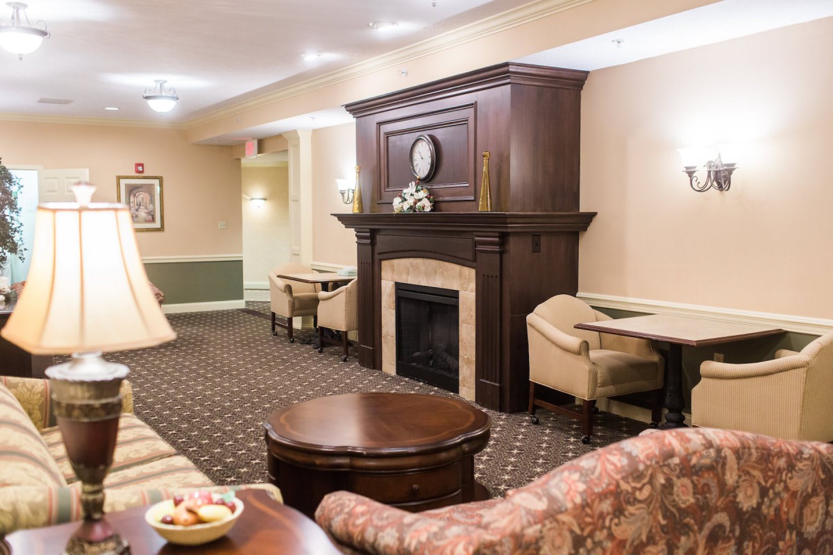 A cozy lounge with comfortable seating and a classic fireplace.