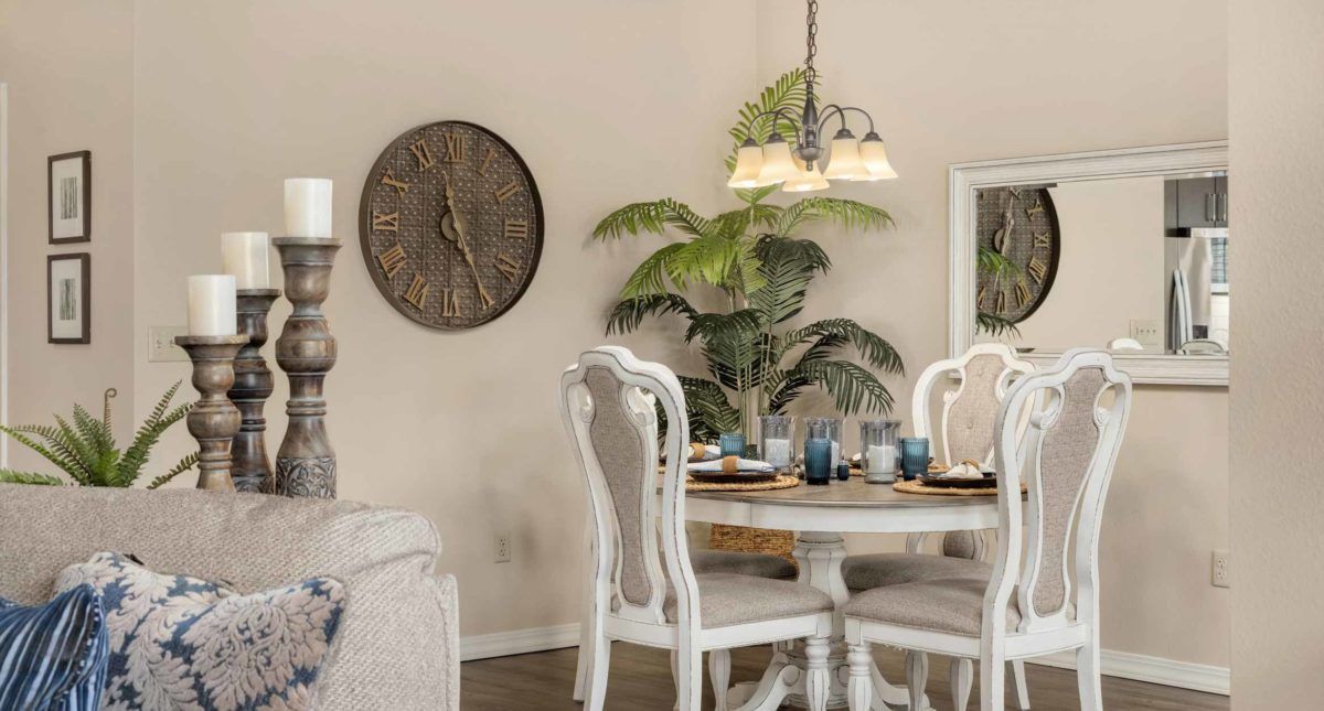 A cozy dining room with a round table, elegant chairs, and soft lighting.